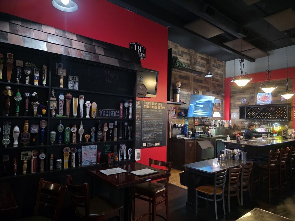 A neighborhood pub interior with sports screens.
